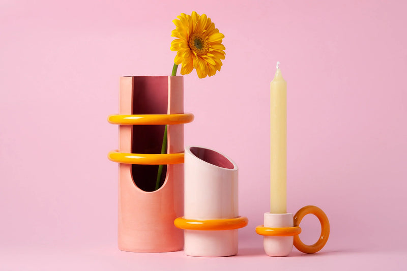 pink and yellow ceramic vase with a big yellow ring on the bottom, by ceramicist Arianna de Luca. Available at www.cuemars.com