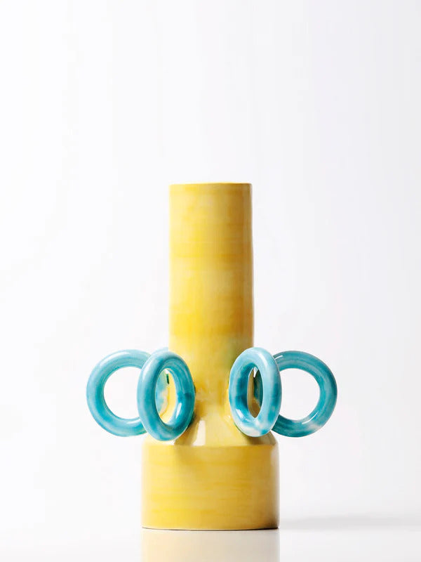 yellow vase with big blue rings as decoration, handmade by italian ceramicist arianna de luca. available at www.cuemars.com