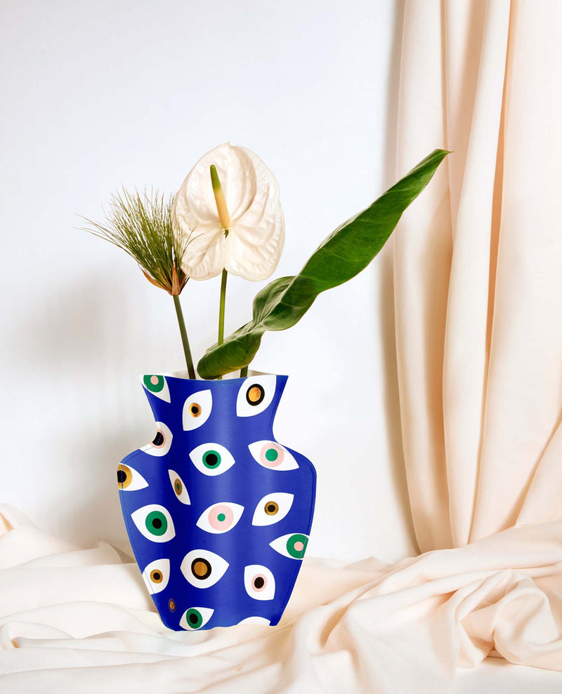 Colourful paper vase filled with Nazar eyes in blue, pink, green and gold. Designed by Spanish brand Octaevo, available at www.cuemars.com