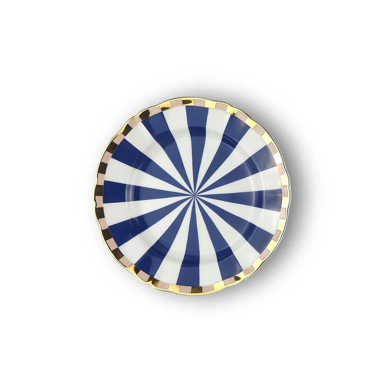 A round porcelain dessert plate from the Bitossi Home Abracadabra collection, featuring a hypnotic blue and white spiral design with a gold-plated rim, blending optical illusion patterns with elegant, whimsical flair.