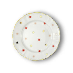 Porcelain dinner plate from Bitossi Home’s Abracadabra collection, showcasing a bold, multicolored starburst pattern with asymmetrical design elements and refined gold detailing around the rim.