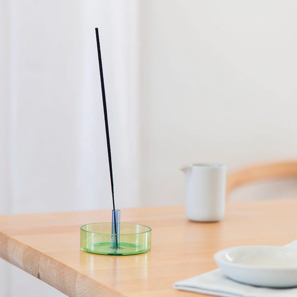 Green and blue glass incense holder with an incense stick on it by British brand Block Design, available at www.cuemars.com