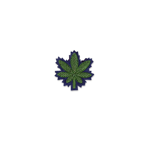 Cannabis green leaf on top of a blue background brooch designed in France by Macon and Lesquoy, ethically made in Pakistan by hand. Available at www.cuemars.com