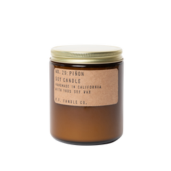 soy wax scented candle in an amber glass jar and metallic lid with a kraft sticker that states Pinon Soy Candle by PF Candle Co.