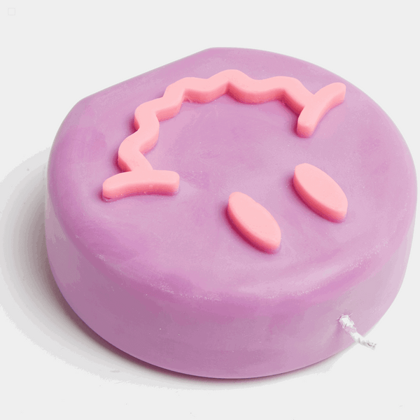 Purple and pink smiley soy wax candle with a wavy smile, by UK based independent brand Wavey Casa, available at www.cuemars.com
