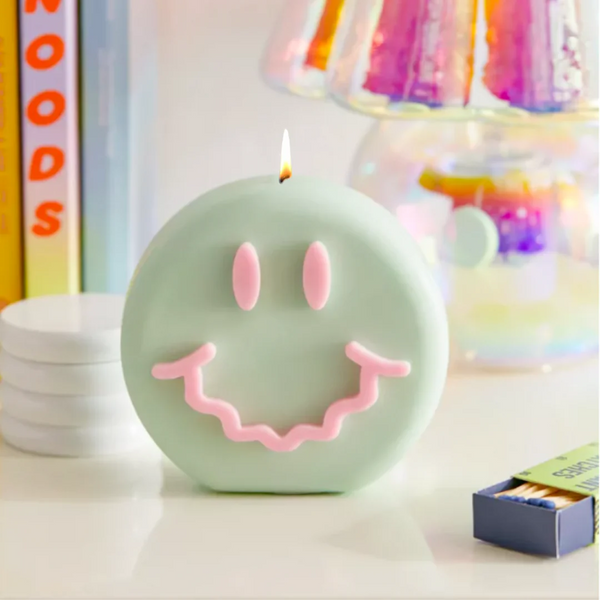 Green and pink smiley soy wax candle with a wavy smile, by UK based independent brand Wavey Casa, available at www.cuemars.com