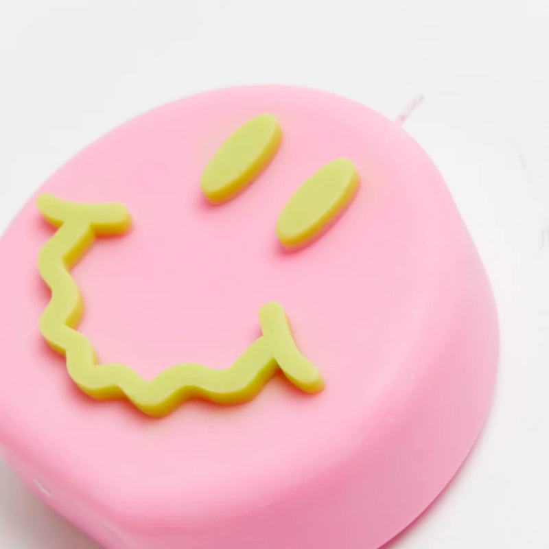Pink and green smiley soy wax candle with a wavy smile, by UK based independent brand Wavey Casa, available at www.cuemars.com
