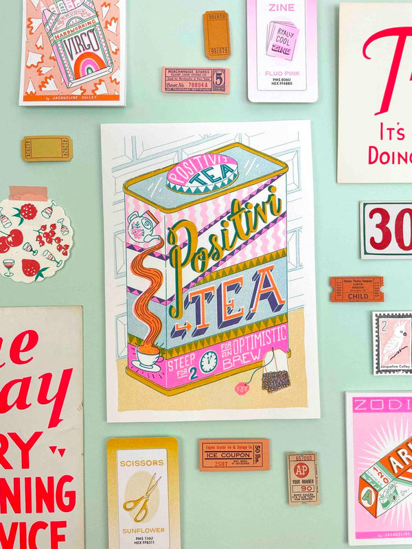 A can of tea that says Positivi-tea Optimistic Brew by Jacqueline Colley. Available at www.cuemars.com