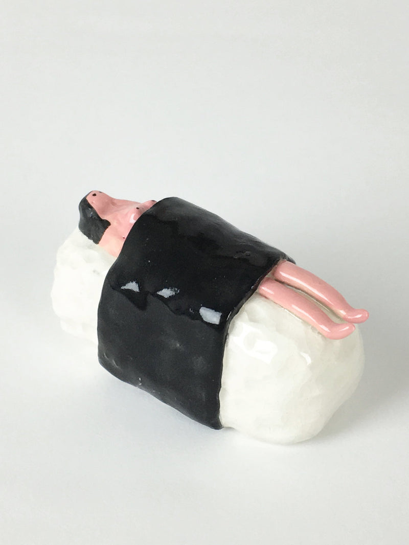 Handmade ceramic of a woman wrapped up in a sushi roll, by Manchester based illustrator Amy Victoria Marsh