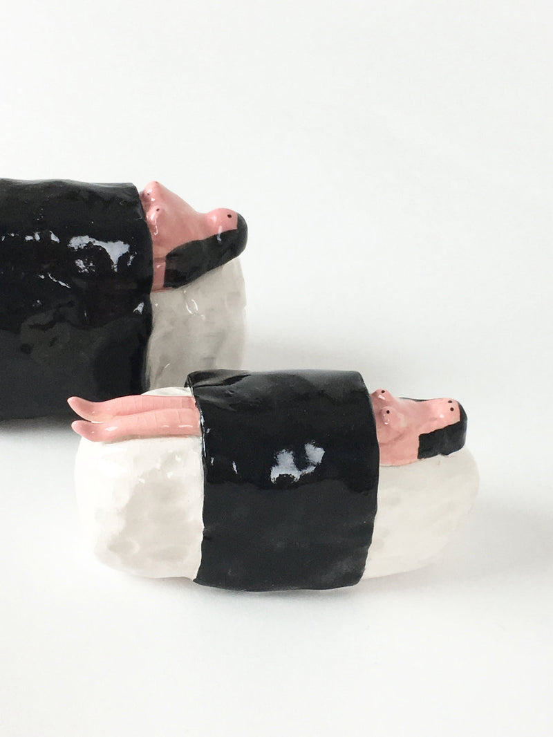 Handmade ceramic of a woman wrapped up in a sushi roll, by Manchester based illustrator Amy Victoria Marsh