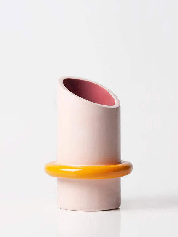 pink and yellow ceramic vase with a big yellow ring on the bottom, by ceramicist Arianna de Luca. Available at www.cuemars.com
