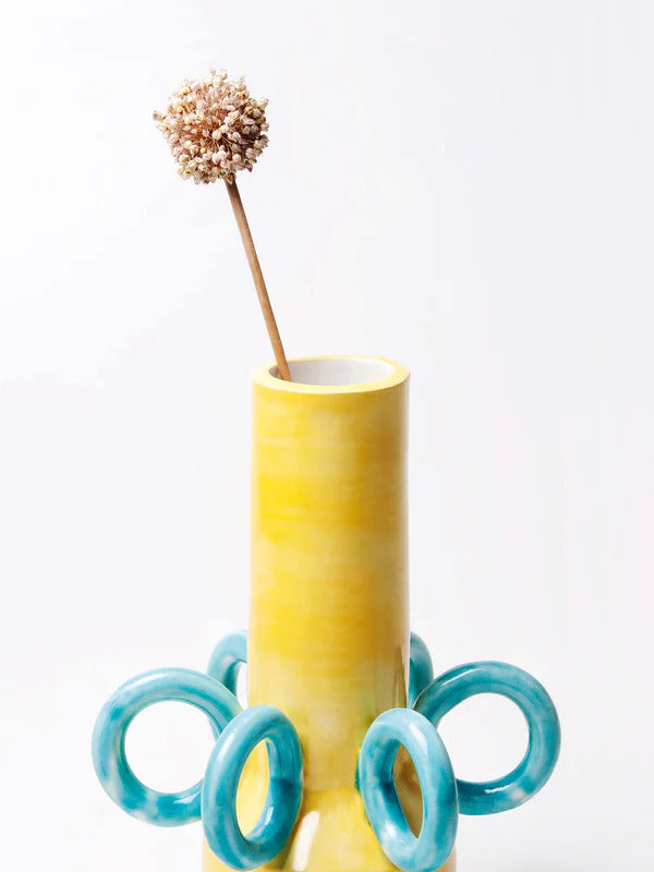 yellow vase with big blue rings as decoration, handmade by italian ceramicist arianna de luca. available at www.cuemars.com