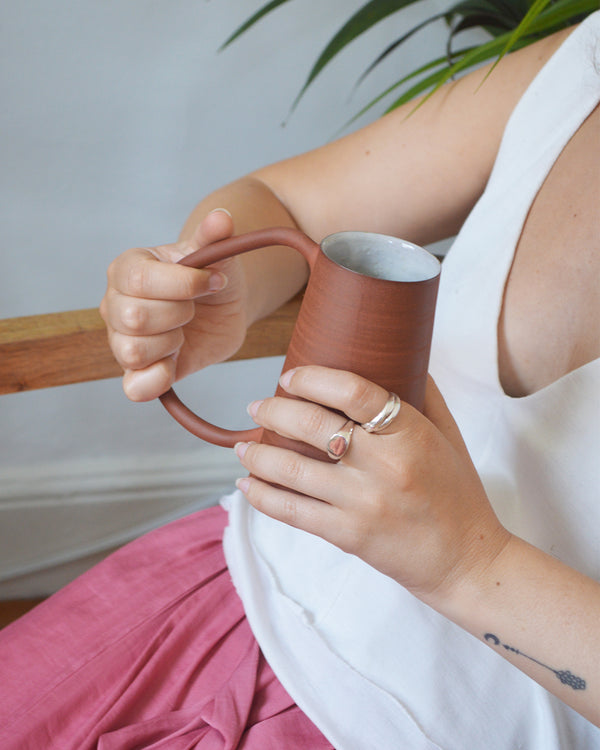 hand thrown coffee mug in red Canadian stoneware in a minimalist design with an oversized handle