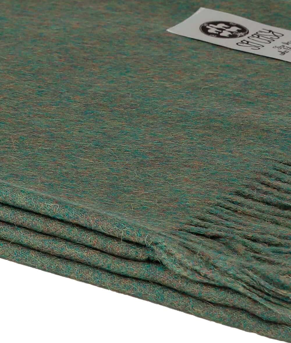 close up picture of handmade super soft baby alpaca throw by so cosy in olive green available online and at the store