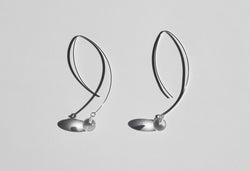 These geometric statement pendant earrings are handmade in Sterling Silver and showcase 2 large rock crystal spheres