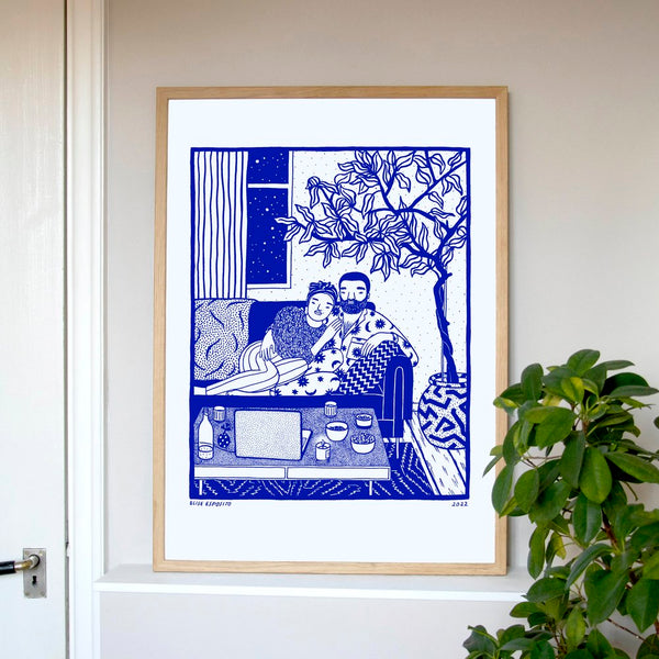 A woman and a man cuddling on a sofa watching something on their laptop in their living room, by French visual artist Elise Esposito. Available at www.cuemars.com
