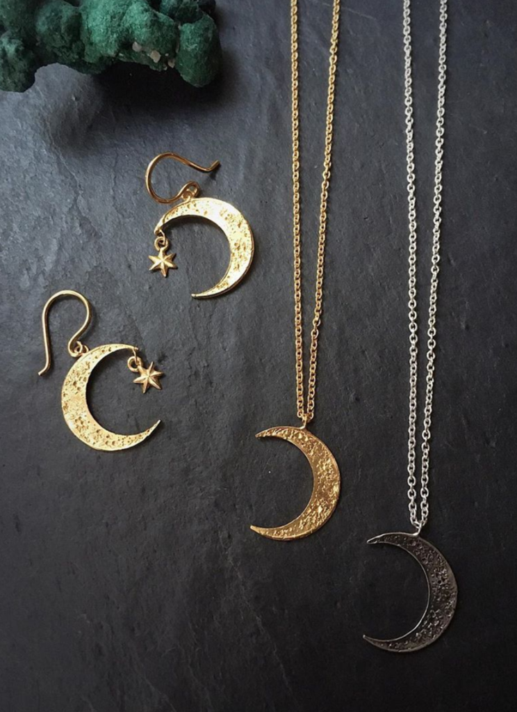 Detailed gold plated crescent moon earrings with hand carved craters and a pendant gold plated star. Two Crescent moon necklaces one in gold plated silver and the other one in oxidised silver. Designed and made by Momocreatura in London.