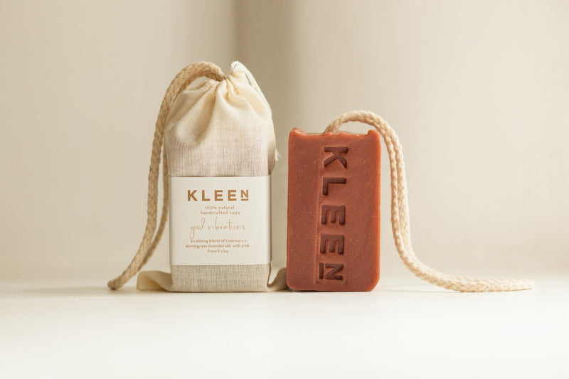 Picture with two French Pink Clay exfoliating soaps on a cotton rope by natural skincare brand Kleen soaps ideal for sensitive skin and a cotton travel bag