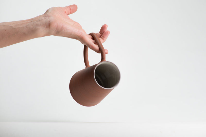 Details of hand thrown coffee mug in red Canadian stoneware with oversized handle and glazed interior