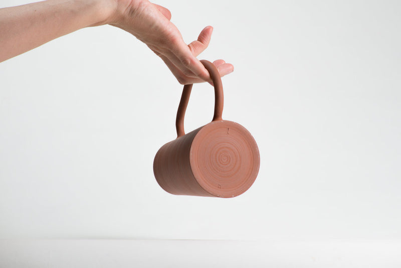 Details of the bottom of the hand thrown coffee mug in red Canadian stoneware by Léa & Nicolas with oversized handle
