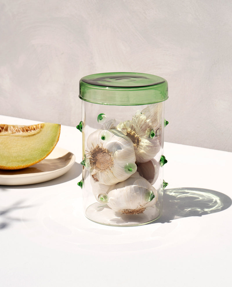 Handmade cylindrical glass container with garlic cloves by design studio Octaevo inspired by the agave plant
