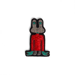 An extraterrestrial creature hand embroidered in grey and green eyes, wearing a red jumper, designed by the French Macon et Lesquoy. Available at www.cuemars.com