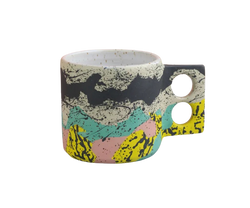 Colourful coffee mug with a geometrical handle with two holes for the fingers by Minx Factory, available at cuemars.com