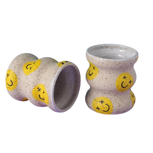 Wavy coffee cups without handles with yellow smiley faces. Designed and handmade by Minx Factory and sold at cuemars.com