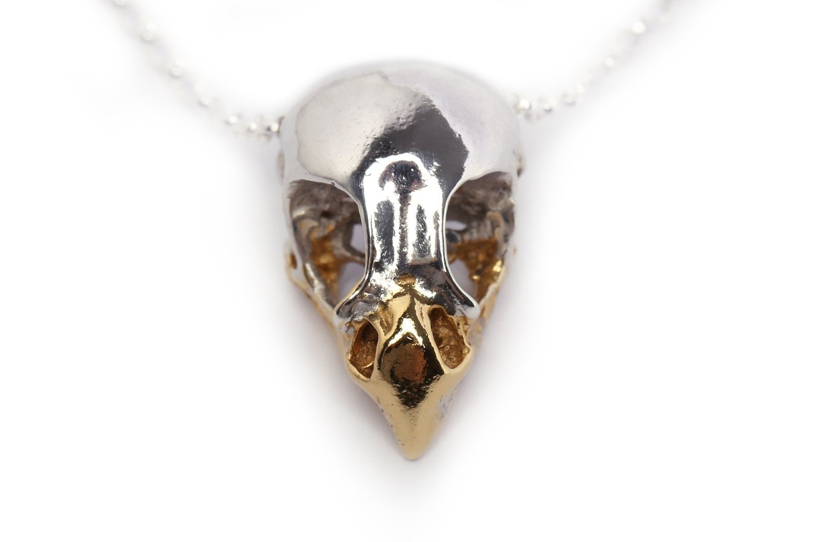 close up details of handmade bird of prey necklace in sterling silver and 24ct gold plated beak