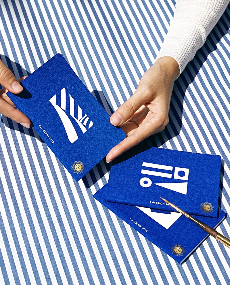 Deep blue pocket notebook with white screen printed illustration on the front and Octaevo's gold stamp, available at cuemars.com
