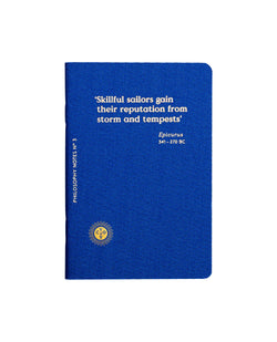 Deep blue small notebook with a poem screen printed on gold that says Skilful sailors gain their reputation from storm and tempests by Epicurus, designed by Octaevo. Available at www.cuemars.com