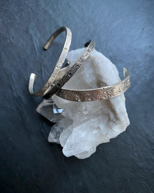 Three Silver moon bangles featuring the moon craters that have been individually marked by hand by independent maker Momocreatura