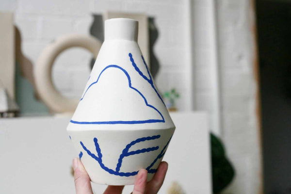 handmade diamond shaped porcelain vase with blue motifs by ceramicist Sophie Alda, available at cuemars.com