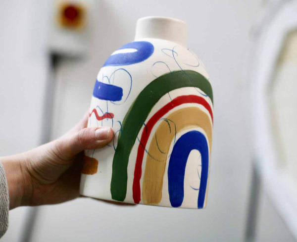 handmade porcelain vase by ceramicist Sophie Alda showcasing a rainbow and different colour brushstrokes that make this handmade piece a unique staple for home. Available at cuemars.com