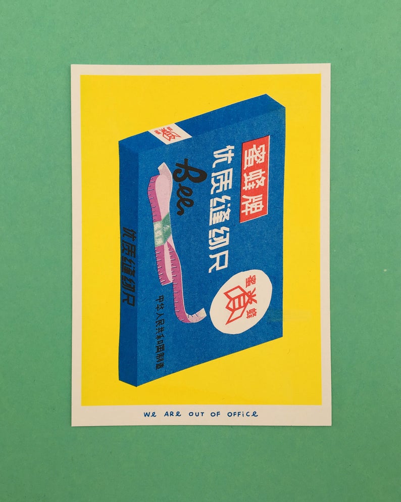 Vibrant risograph print of a blue box of colourful cloth tape measures on a bright yellow background. Designed and printed by Dutch company We are out of office.